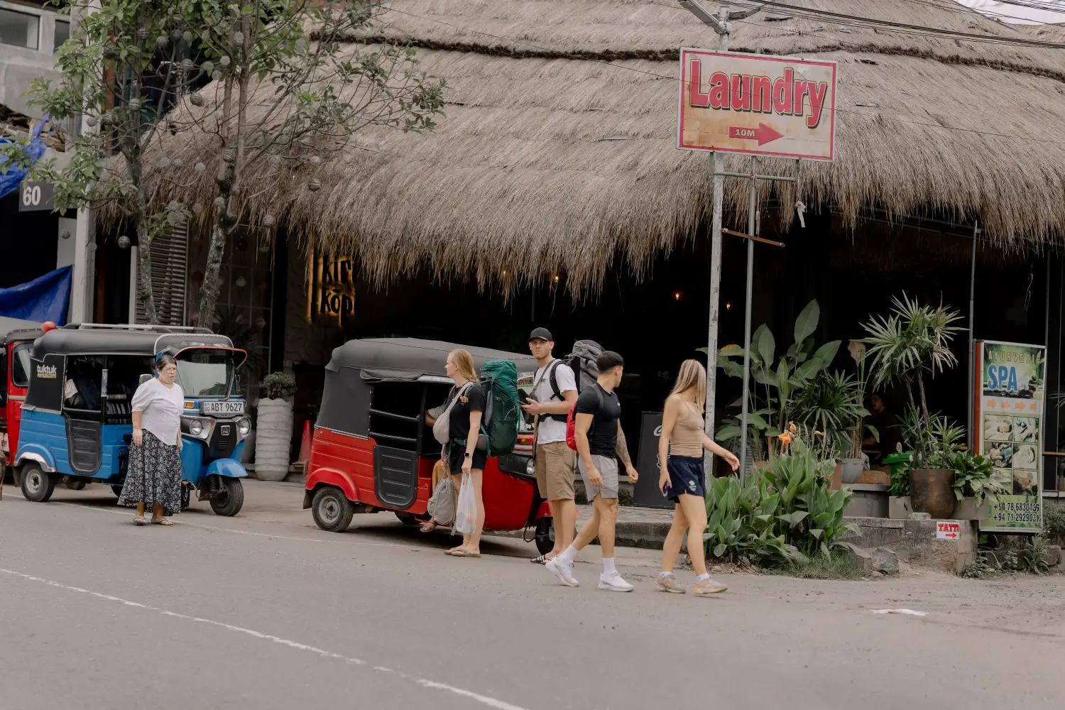 tourists and tuk-tuks on a busy street in a sri lankan town.