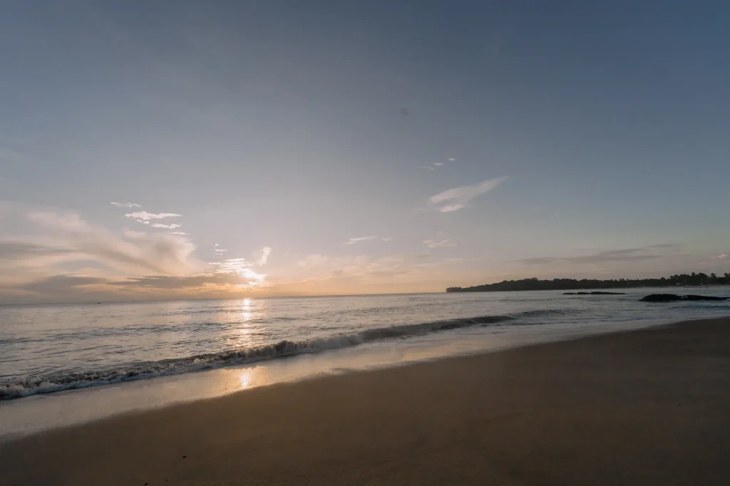 a tranquil sunrise over a sri lankan beach with soft waves.