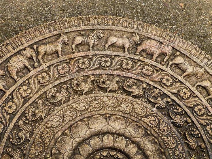 a carved sri lankan moonstone with concentric animal carvings.