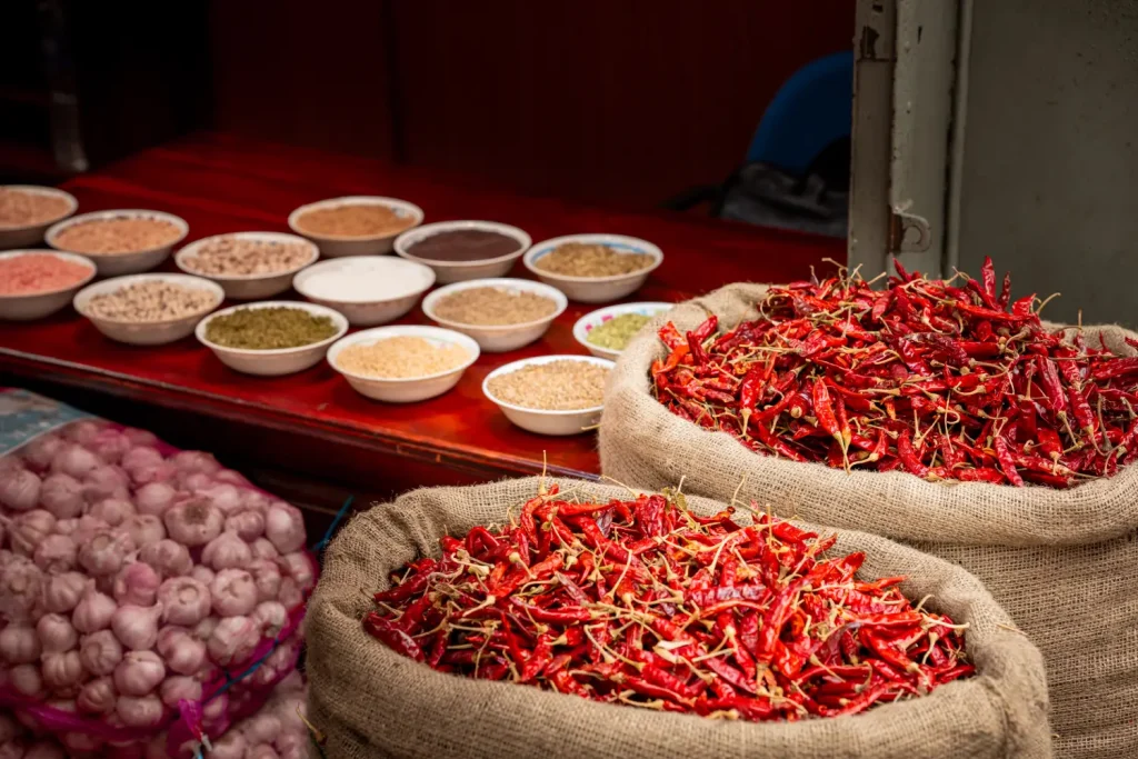 sacks of red chilies and bowls of spices at a sri lankan market.