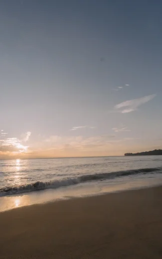 a tranquil sunrise over a sri lankan beach with soft waves.